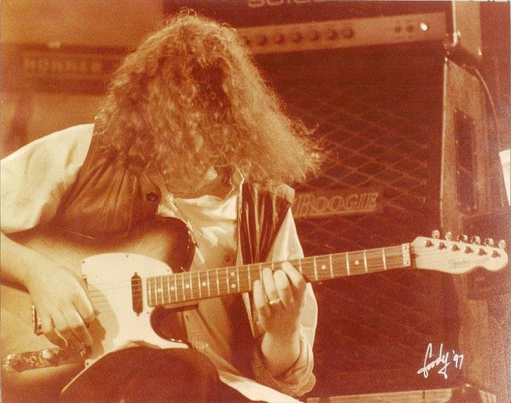Michael Houser of Widespread Panic playing guitar seated
